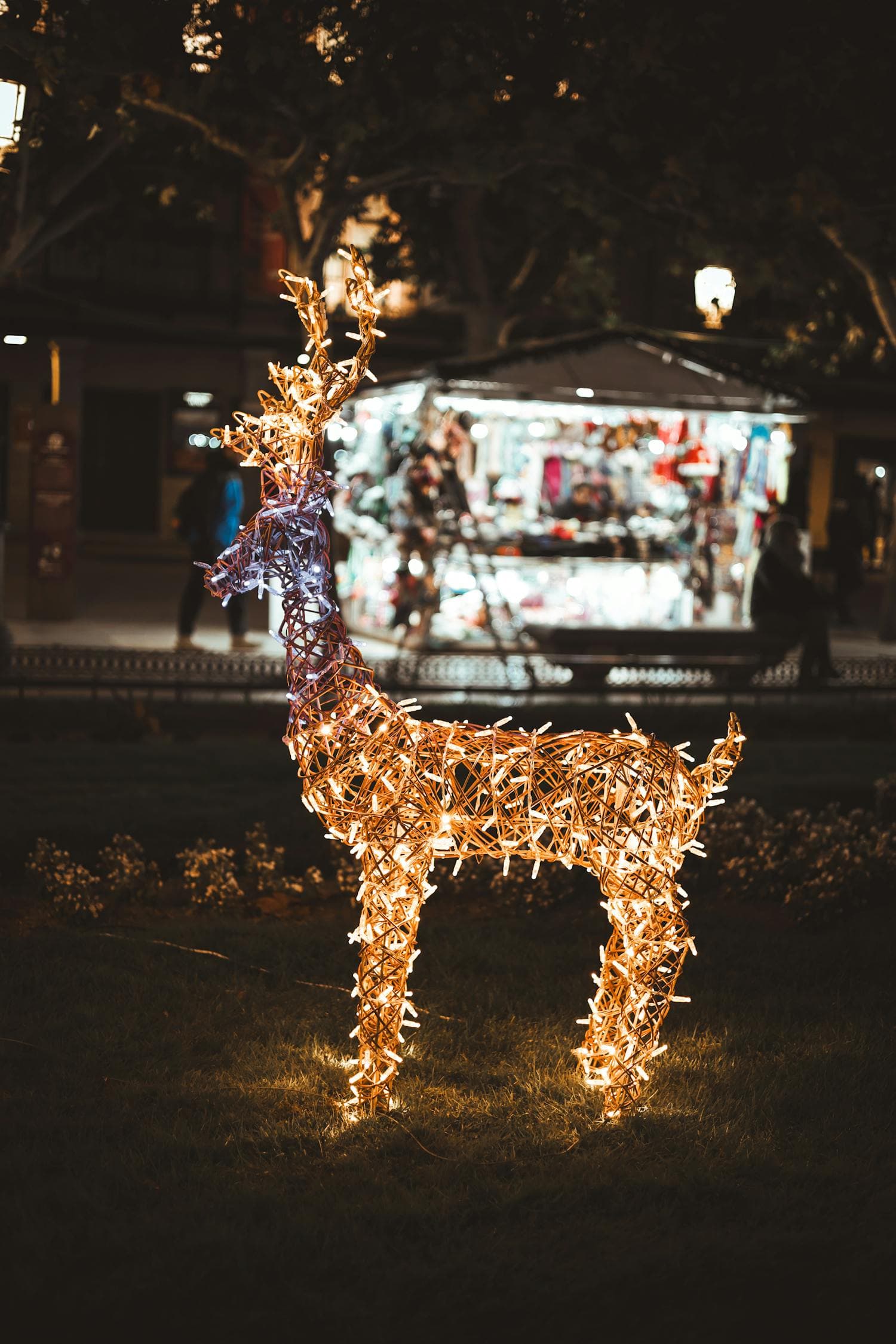 An outdoor lit reindeer figure glowing warmly in the evening on a snowy front yard, single warm-white light temperature throughout, the kind of yard tableau a ranch home rewards