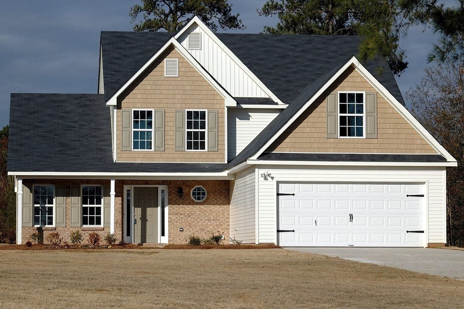 A two-story suburban colonial home, undecorated, on a clear winter afternoon