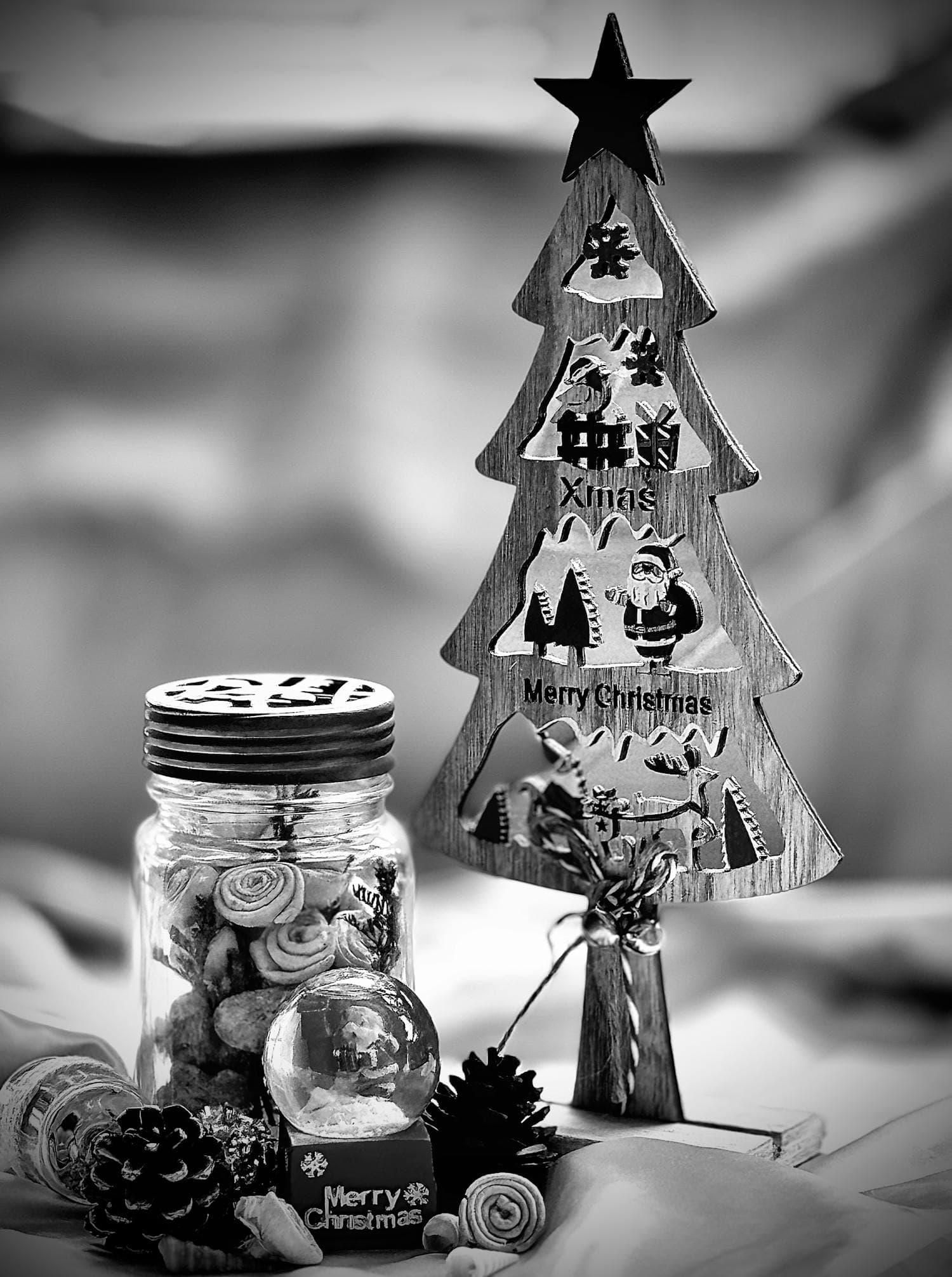 An elegant black-and-white modern farmhouse Christmas scene with a wooden tree structure, wrapped gifts in black and white paper, and matte black ornaments, the entire arrangement built on a restrained monochrome palette