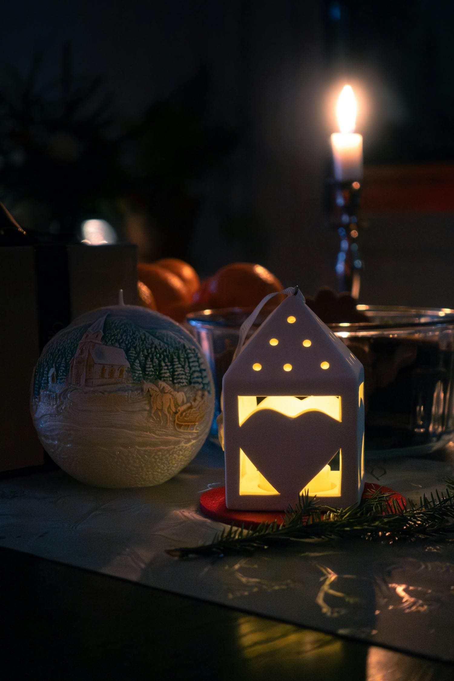 A festive Scandinavian-style Christmas table setting bathed in soft warm candlelight, with simple natural greenery, neutral linens, and restrained holiday ornaments, the kind of unhurried hygge scene the style is built around